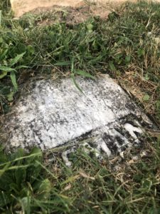 A piece of Henry Freeman's headstone embedded in the ground.