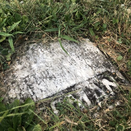 A piece of Henry Freeman's headstone embedded in the ground.